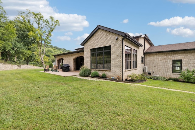 back of house with a patio and a yard