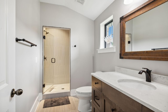 bathroom featuring vaulted ceiling, toilet, vanity, and a shower with shower door