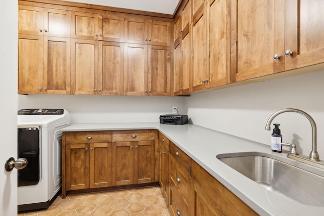 washroom with cabinets, washer / clothes dryer, and sink