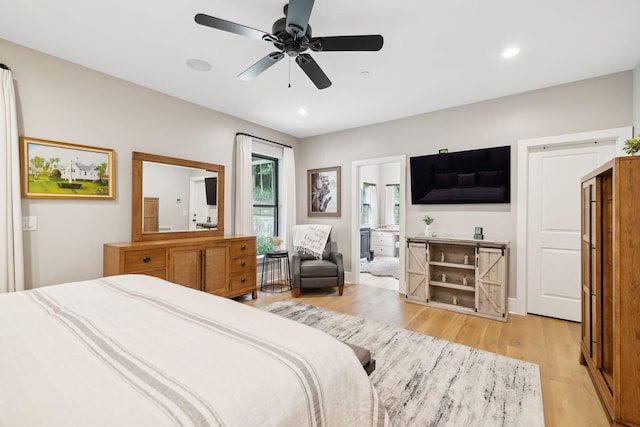 bedroom with ceiling fan, ensuite bath, and light hardwood / wood-style flooring