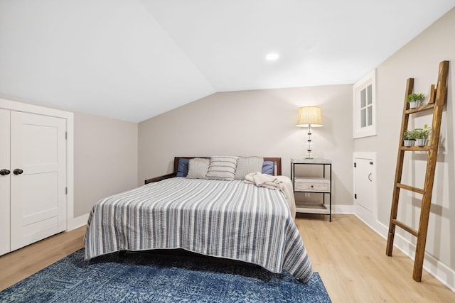 bedroom with lofted ceiling and light hardwood / wood-style floors