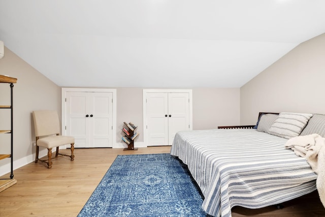 bedroom featuring lofted ceiling and light hardwood / wood-style floors