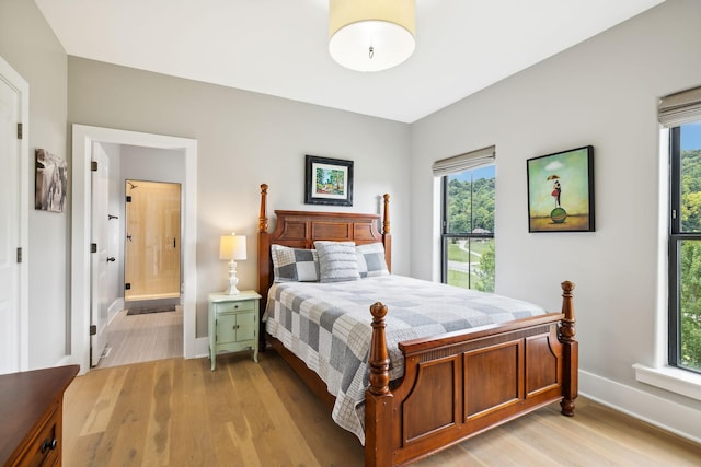 bedroom with light hardwood / wood-style flooring and ensuite bathroom