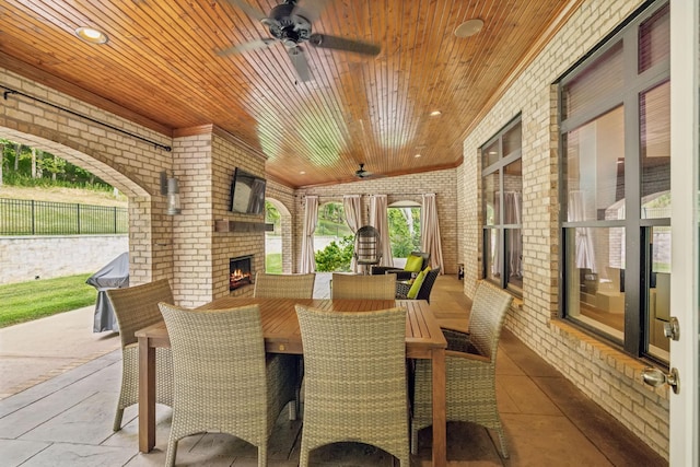 view of patio / terrace featuring an outdoor brick fireplace and ceiling fan