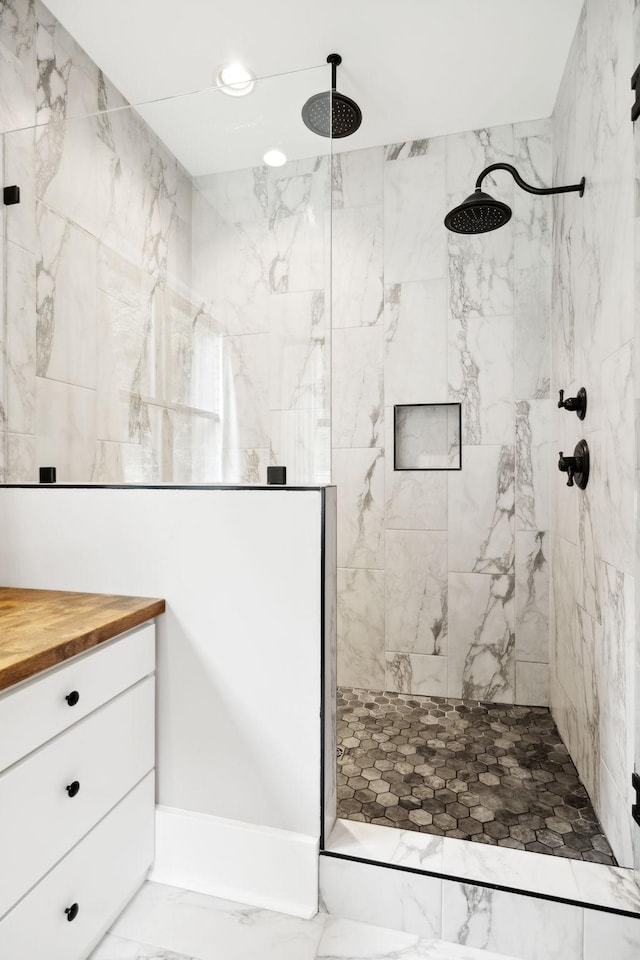 bathroom featuring a tile shower and vanity