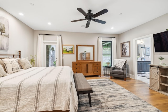 bedroom featuring ceiling fan, ensuite bath, light hardwood / wood-style floors, and access to outside