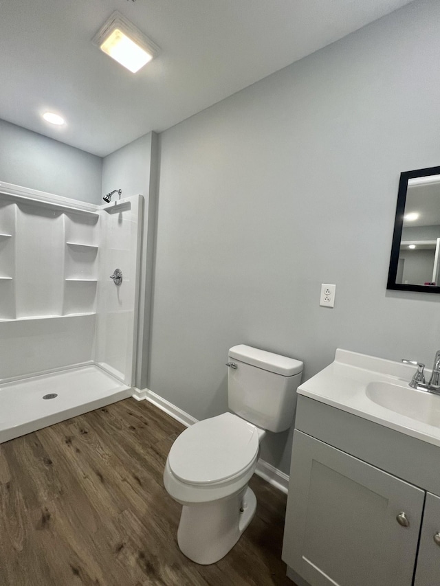 bathroom featuring vanity, toilet, hardwood / wood-style floors, and walk in shower