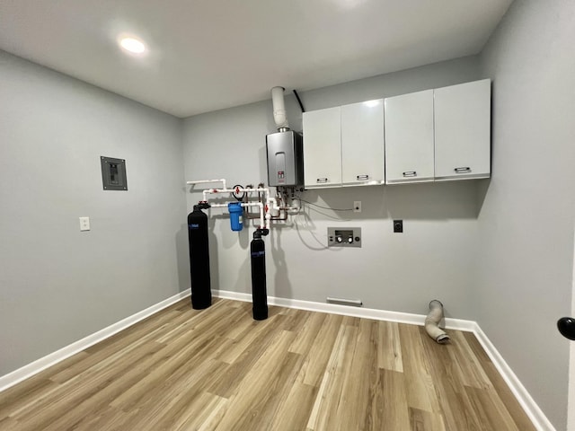 clothes washing area featuring water heater, hookup for a washing machine, cabinets, hookup for an electric dryer, and light wood-type flooring