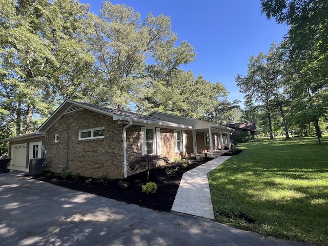 view of front of home featuring central AC, a garage, and a front yard