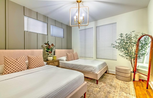 bedroom featuring an inviting chandelier and light wood-type flooring