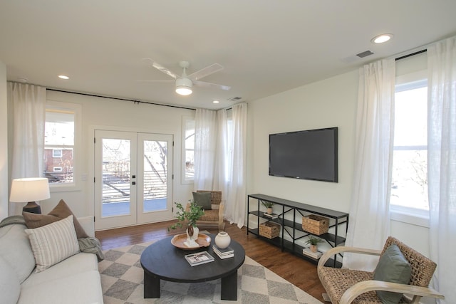 living room with french doors, ceiling fan, and dark wood-type flooring