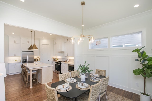 dining space featuring ornamental molding, dark hardwood / wood-style floors, sink, and a notable chandelier