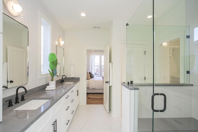 bathroom featuring a shower with door and vanity