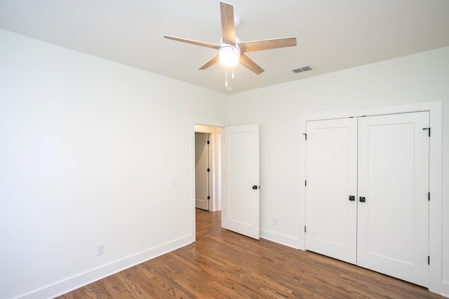 unfurnished bedroom with ceiling fan, hardwood / wood-style floors, and a closet