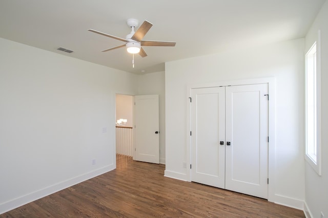 unfurnished bedroom featuring dark hardwood / wood-style flooring, a closet, and ceiling fan