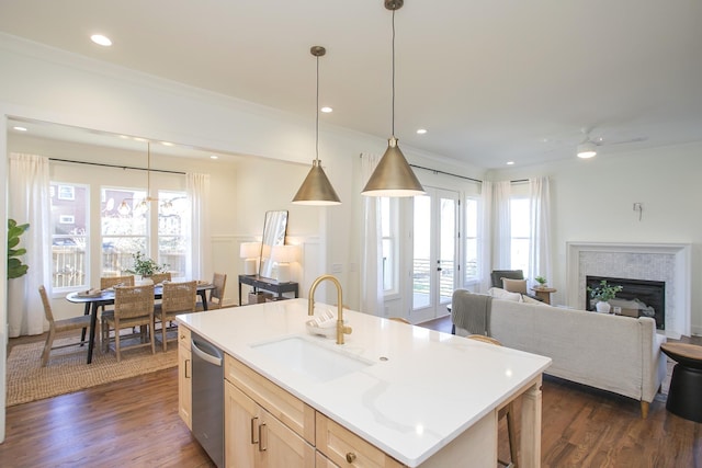 kitchen featuring sink, dishwasher, a kitchen island with sink, a healthy amount of sunlight, and light brown cabinetry