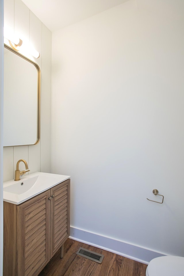 bathroom with vanity, hardwood / wood-style flooring, and toilet