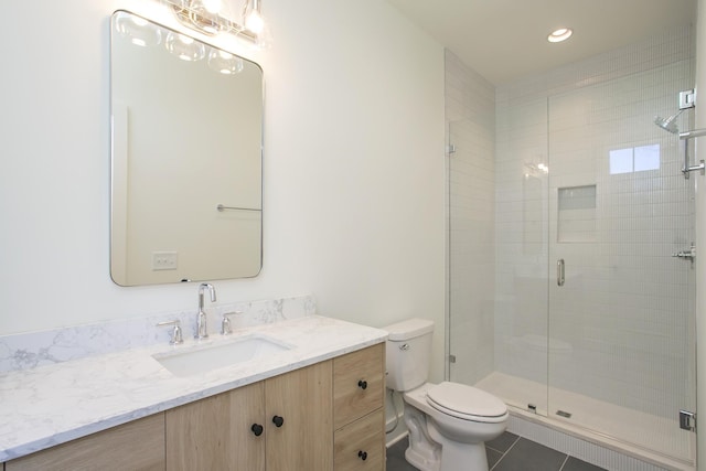 bathroom with tile patterned flooring, vanity, walk in shower, and toilet