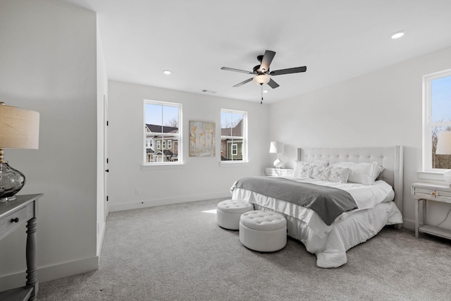 bedroom featuring multiple windows, ceiling fan, and light carpet