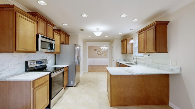 kitchen featuring sink, appliances with stainless steel finishes, ornamental molding, light stone countertops, and kitchen peninsula