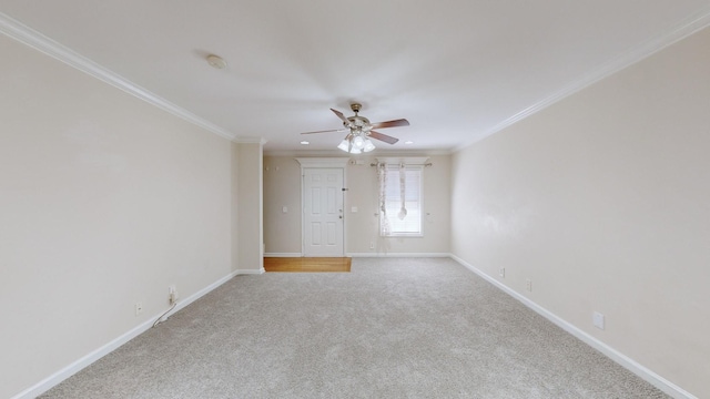 spare room with crown molding, light colored carpet, and ceiling fan