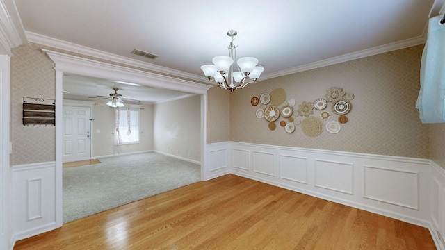 empty room with crown molding, ceiling fan with notable chandelier, and hardwood / wood-style flooring