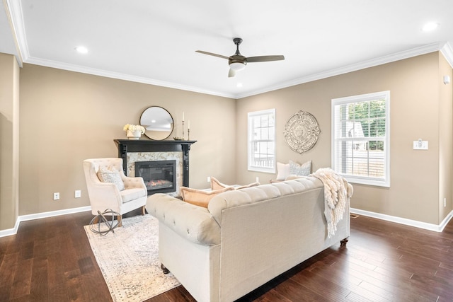 living room featuring a premium fireplace, crown molding, dark hardwood / wood-style floors, and ceiling fan