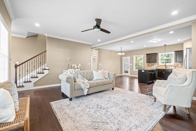 living room featuring ornamental molding, dark hardwood / wood-style floors, and ceiling fan with notable chandelier