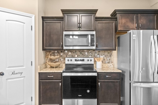 kitchen with light stone counters, dark brown cabinets, stainless steel appliances, and decorative backsplash