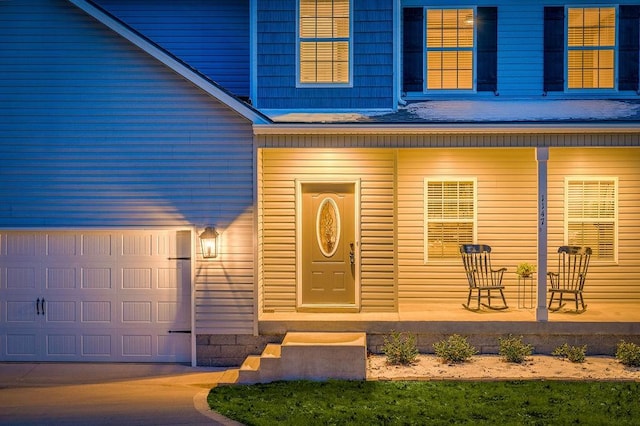 entrance to property featuring a garage and covered porch