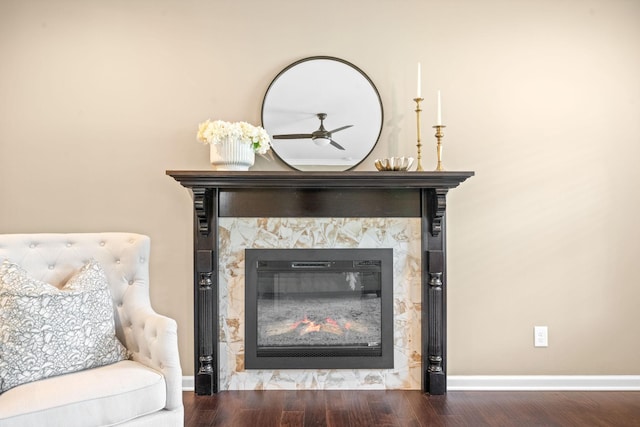 room details featuring hardwood / wood-style flooring, ceiling fan, and a stone fireplace