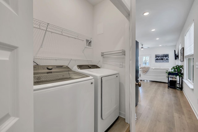 clothes washing area featuring light hardwood / wood-style flooring, washing machine and dryer, and ceiling fan