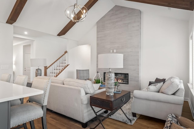 living room with high vaulted ceiling, dark hardwood / wood-style floors, a chandelier, and a fireplace