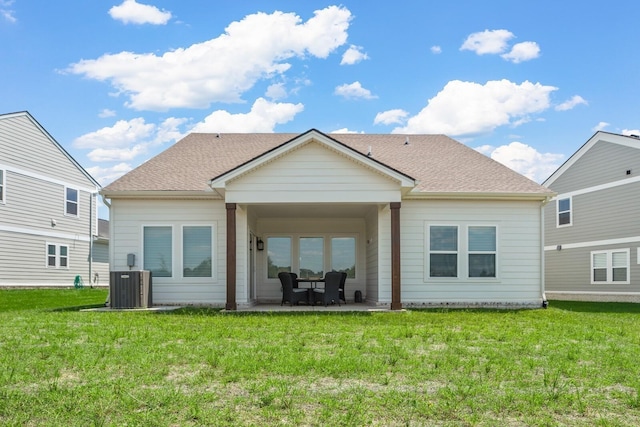 rear view of house featuring a yard, central AC unit, and a patio area