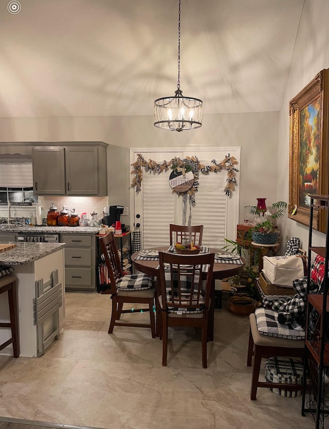 dining area featuring lofted ceiling and a notable chandelier