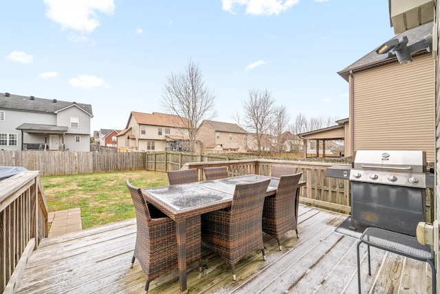 wooden terrace with a grill and a lawn