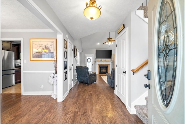 entryway featuring lofted ceiling, ornamental molding, dark hardwood / wood-style floors, and a textured ceiling