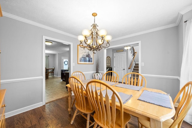 dining area with a textured ceiling, ornamental molding, dark hardwood / wood-style floors, and a chandelier