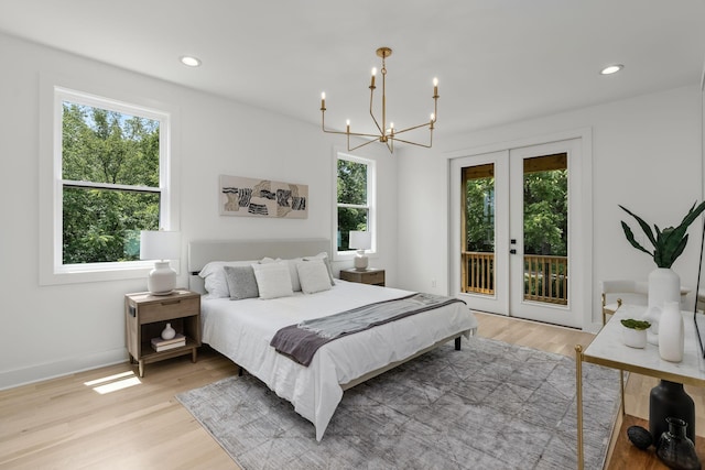 bedroom with french doors, a chandelier, light hardwood / wood-style flooring, and access to outside