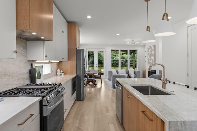 kitchen featuring white cabinetry, appliances with stainless steel finishes, sink, and pendant lighting