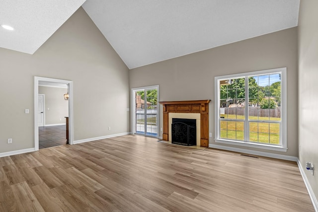 unfurnished living room with light hardwood / wood-style floors and high vaulted ceiling