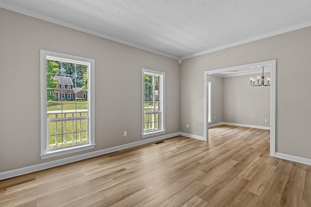 spare room with crown molding, a chandelier, a textured ceiling, and light hardwood / wood-style flooring