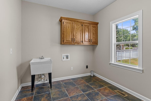 laundry room with washer hookup, a wealth of natural light, and cabinets