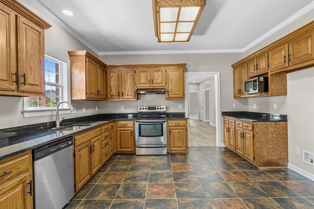 kitchen with crown molding, stainless steel appliances, sink, and a textured ceiling