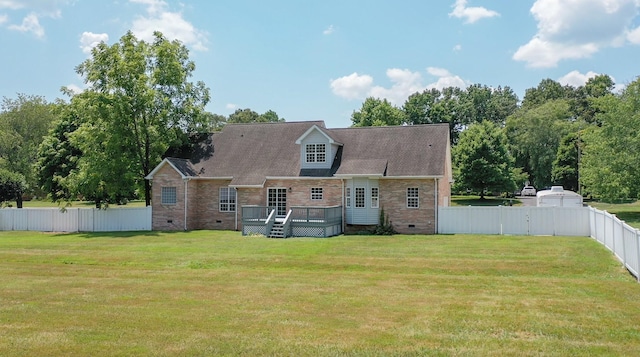 rear view of house with a wooden deck and a lawn