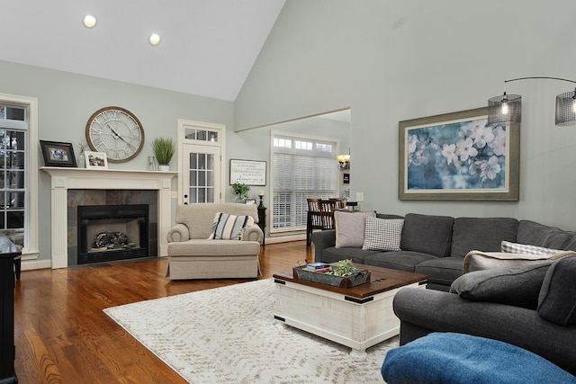 living room featuring a fireplace, dark hardwood / wood-style flooring, and high vaulted ceiling