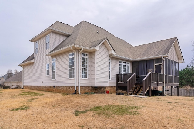 back of property with a wooden deck, a yard, and a sunroom