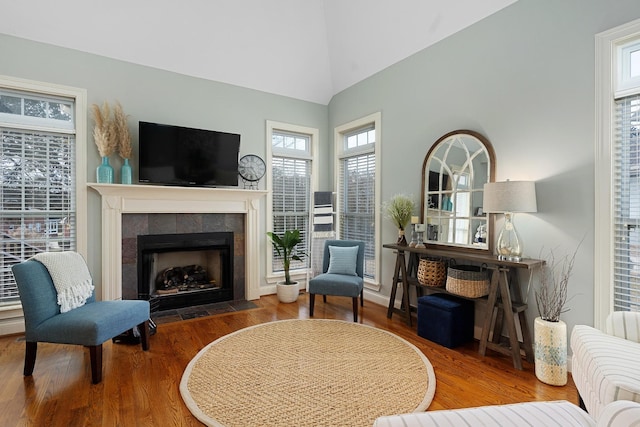 sitting room featuring vaulted ceiling, a fireplace, and hardwood / wood-style floors