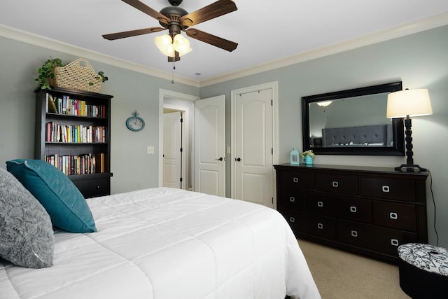 carpeted bedroom featuring crown molding and ceiling fan