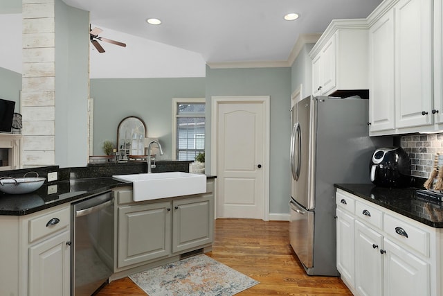 kitchen featuring appliances with stainless steel finishes, sink, white cabinets, and decorative backsplash